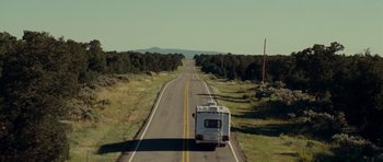 Movie still from “Paul” (2011), directed by Greg Mottola – An rv traveling down a road in the middle of the day; Extreme Wide shot, High angle