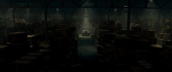 Movie still from “Paul” (2011), directed by Greg Mottola – A warehouse filled with lots of wooden boxes; Extreme Wide shot, High angle
