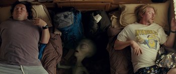 Movie still from “Paul” (2011), directed by Greg Mottola – An alien laying on the ground in a room; Wide shot, Overhead angle