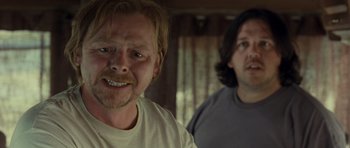 Movie still from “Paul” (2011), directed by Greg Mottola – Two men standing next to each other in front of a window; Close Up shot, Over the shoulder angle