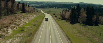 Movie still from “Paul” (2011), directed by Greg Mottola – A bus driving down a road in the middle of a field; Extreme Wide shot, High angle