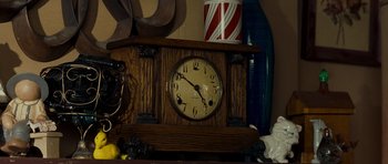 An old clock sitting on top of a wooden table