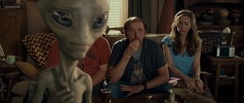 Movie still from “Paul” (2011), directed by Greg Mottola – A group of people sitting around a living room; Medium shot, Over the shoulder angle