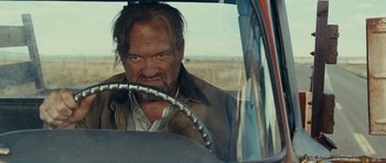 Movie still from “Paul” (2011), directed by Greg Mottola – A man with a beard driving a car in a field; Close Up shot, Low angle