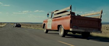 Movie still from “Paul” (2011), directed by Greg Mottola – An orange truck is driving down the road; Wide shot, Low angle