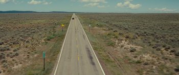 Movie still from “Paul” (2011), directed by Greg Mottola – An aerial view of an empty road with a car driving down it; Extreme Wide shot, High angle