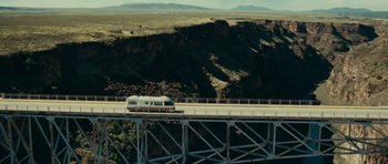 Movie still from “Paul” (2011), directed by Greg Mottola – A bus is driving on a bridge over a river; Extreme Wide shot, High angle
