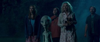 Movie still from “Paul” (2011), directed by Greg Mottola – A group of people standing next to each other in the dark; Medium shot, Over the shoulder angle