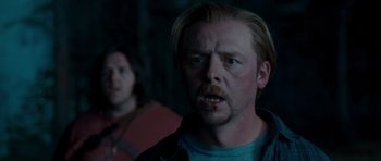 Movie still from “Paul” (2011), directed by Greg Mottola – A man with blonde hair and blue eyes is looking at the camera; Close Up shot, Over the shoulder angle