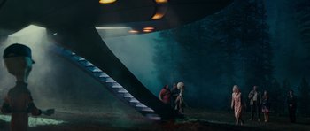 Movie still from “Paul” (2011), directed by Greg Mottola – Two people standing in front of a staircase in the woods; Extreme Wide shot, Low angle