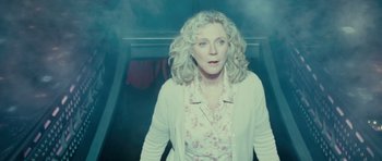 Movie still from “Paul” (2011), directed by Greg Mottola – A woman standing on a staircase in the dark; Medium shot, Low angle