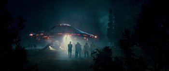 Movie still from “Paul” (2011), directed by Greg Mottola – A group of people standing in front of an alien ship; Extreme Wide shot, Low angle