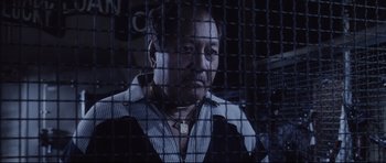Movie still from “Payback” (1999), directed by Brian Helgeland – A man in a jail cell looking at the camera; Close Up shot, Low angle