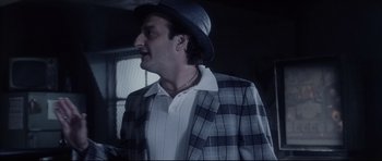 Movie still from “Payback” (1999), directed by Brian Helgeland – A man wearing a hat and a jacket; Medium shot, Low angle