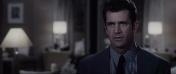 Movie still from “Payback” (1999), directed by Brian Helgeland – A man wearing a suit and tie in front of a mirror; Close Up shot, Over the shoulder angle