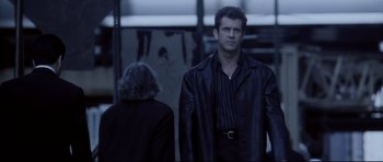 Movie still from “Payback” (1999), directed by Brian Helgeland – A man and a woman standing next to each other in front of a building; Medium shot, Low angle