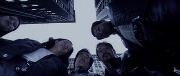 Movie still from “Payback” (1999), directed by Brian Helgeland – A group of men standing next to each other in front of a building; Medium shot, Overhead angle