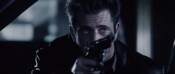 Movie still from “Payback” (1999), directed by Brian Helgeland – A person holding a gun; Close Up shot, Over the shoulder angle