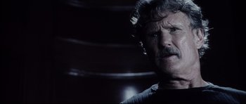 Movie still from “Payback” (1999), directed by Brian Helgeland – An older man with a beard and mustache looking at the camera; Close Up shot, Low angle