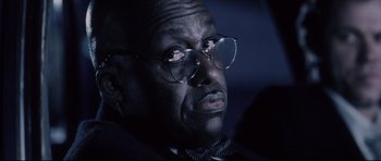 Movie still from “Payback” (1999), directed by Brian Helgeland – An older man wearing glasses and a bow tie; Close Up shot, Low angle