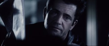 Movie still from “Payback” (1999), directed by Brian Helgeland – A person wearing a black jacket; Close Up shot, Over the shoulder angle