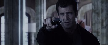 Movie still from “Payback” (1999), directed by Brian Helgeland – A man holding a remote control in his hand; Close Up shot, Over the shoulder angle