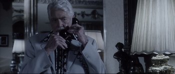 Movie still from “Payback” (1999), directed by Brian Helgeland – An older man holding a phone up to his ear; Close Up shot, High angle