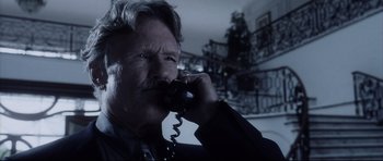 Movie still from “Payback” (1999), directed by Brian Helgeland – A man talking on a phone while wearing a suit; Close Up shot, Low angle