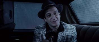 Movie still from “Payback” (1999), directed by Brian Helgeland – A man in a hat and a jacket holding a gun; Close Up shot, High angle