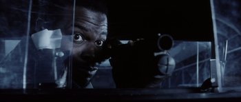 Movie still from “Payback” (1999), directed by Brian Helgeland – A man holding a gun in front of his face; Close Up shot, Over the shoulder angle