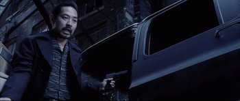 Movie still from “Payback” (1999), directed by Brian Helgeland – A man holding a gun in front of a car; Close Up shot, Over the shoulder angle