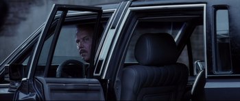 Movie still from “Payback” (1999), directed by Brian Helgeland – A man sitting in the passenger seat of a car looking out of the window; Close Up shot, Over the shoulder angle