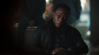 Movie still from “Peacemaker” (2022), created by James Gunn – A man in a black jacket looking at the camera; Close Up shot, Over the shoulder angle