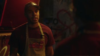 Movie still from “Peacemaker” (2022), created by James Gunn – A man wearing an apron and a hat; Medium shot, Over the shoulder angle