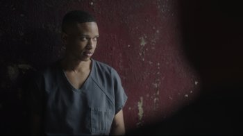 Movie still from “Peacemaker” (2022), created by James Gunn – A man standing in front of a red wall; Close Up shot, Over the shoulder angle