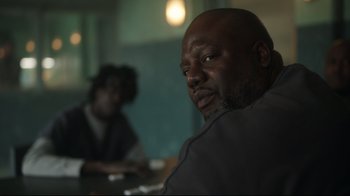 Movie still from “Peacemaker” (2022), created by James Gunn – A man sitting in front of another man in front of a mirror; Close Up shot, Over the shoulder angle