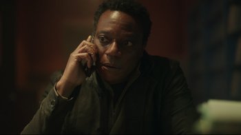 Movie still from “Peacemaker” (2022), created by James Gunn – A man is talking on a cell phone; Close Up shot, Low angle