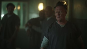 Movie still from “Peacemaker” (2022), created by James Gunn – A group of people standing in a room; Close Up shot, Over the shoulder angle