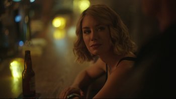 Movie still from “Peacemaker” (2022), created by James Gunn – A woman sitting on a chair in a dark room; Close Up shot, Over the shoulder angle