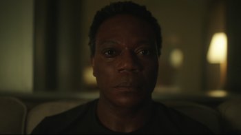 Movie still from “Peacemaker” (2022), created by James Gunn – A man's face in a dark room; Close Up shot, Low angle