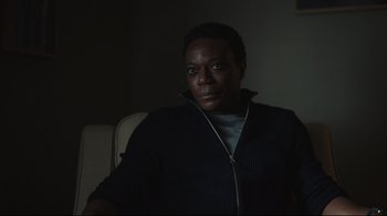 Movie still from “Peacemaker” (2022), created by James Gunn – A man sitting in a chair in the dark; Close Up shot, Low angle