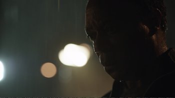 Movie still from “Peacemaker” (2022), created by James Gunn – A person's face in the dark; Close Up shot, Low angle