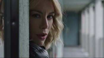 Movie still from “Peacemaker” (2022), created by James Gunn – A person wearing a jacket near a wall; Close Up shot, Low angle