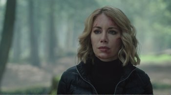 Movie still from “Peacemaker” (2022), created by James Gunn – A woman in a black jacket is looking into the distance; Close Up shot, Over the shoulder angle