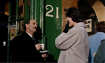 Movie still from “Peeping Tom” (1960), directed by Michael Powell – A man and a woman standing next to each other; Medium shot, Over the shoulder angle