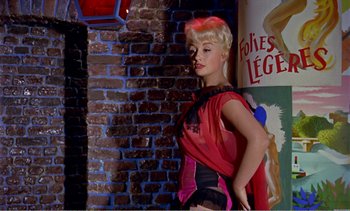 Movie still from “Peeping Tom” (1960), directed by Michael Powell – A woman standing in front of a brick wall; Medium shot, Low angle