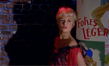 Movie still from “Peeping Tom” (1960), directed by Michael Powell – A woman with blonde hair wearing a red dress; Close Up shot, Low angle