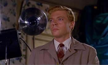 Movie still from “Peeping Tom” (1960), directed by Michael Powell – A man wearing a suit and tie in front of an electric fan; Close Up shot, Low angle