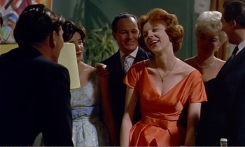 Movie still from “Peeping Tom” (1960), directed by Michael Powell – A group of people standing next to each other in a room; Medium shot, Over the shoulder angle