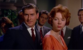 Movie still from “Peeping Tom” (1960), directed by Michael Powell – A man and a woman standing next to each other in front of other men; Close Up shot, Low angle